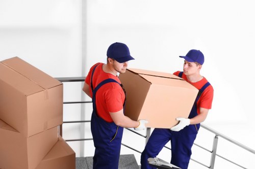 Local house removals team handling packed boxes outside a family home in House