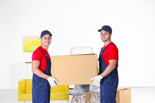 Furniture removal team collecting a sofa from inside a house