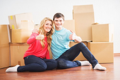 Moving crew navigating stairs and narrow access at a house